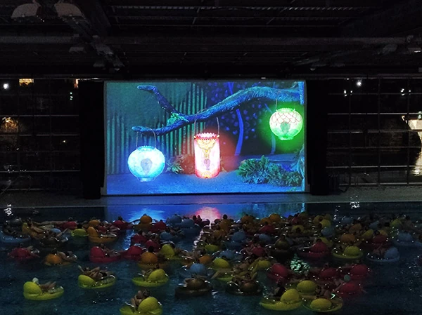 Photo d'une projection cinématographique dans une piscine. Les spécateurs sont dans la piscine à regarder un film.